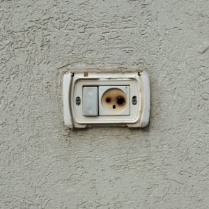 שקע חשמלי בקיר עם כיסוי פגום