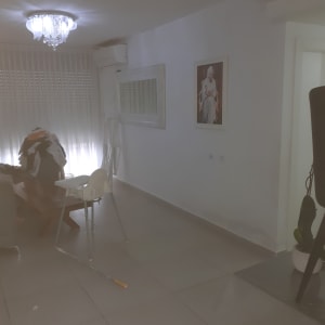 קיר צבוע עם תמונה, סולם ומברשת על הרצפה