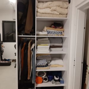 ארון בגדים עם בגדים מקופלים ומעילים תלויים