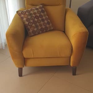 כורסה צהובה עם כרית מעוצבת על מושב