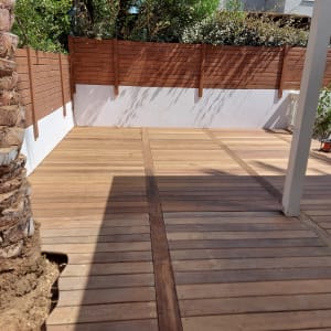 דק עץ בגינה עם גדר עץ מסביב