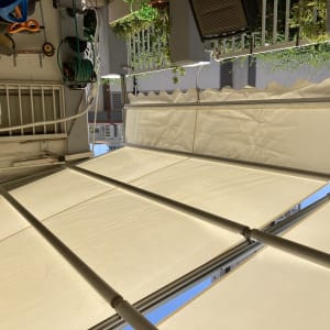 סוכך בד לבן עם מסגרת מתכת במרפסת