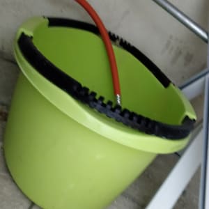 דלי ירוק עם צינור אדום מחובר