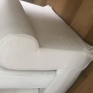 ספה לבנה עם ריפוד נקי על רצפת עץ