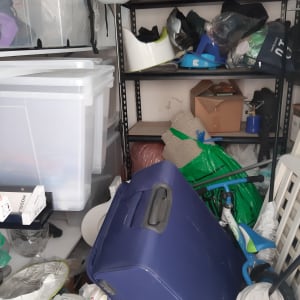 חדר מבולגן עם קופסאות פלסטיק ומזוודה כחולה