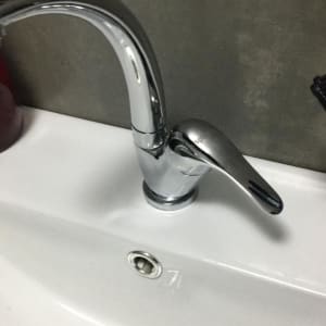 ברז כרום מותקן על כיור לבן עם ניקוז