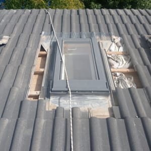 חלון גג מותקן על גג רעפים אפור