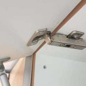 ציר מתכת מחובר לדלת ארון לבנה