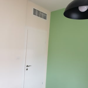 קיר צבוע בצבע ירוק בהיר ליד דלת לבנה