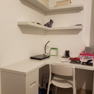 שולחן עבודה לבן עם מדפים תלויים על הקיר