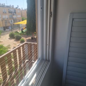 חלון עם תריסים חדשים בתהליך התקנה
