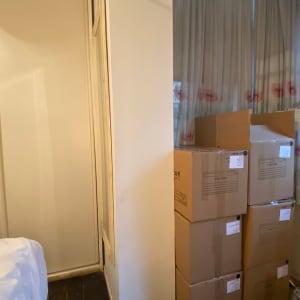 שישה קרטונים חומים מונחים ליד קיר לבן