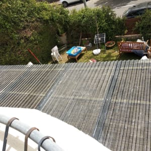 גג פלסטיק שקוף מעל גינה עם ריהוט עץ