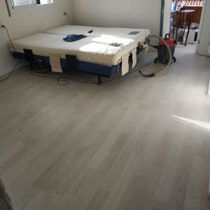 רצפת פרקט בהירה בחדר עם שואב אבק