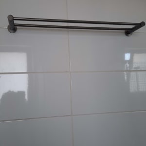 מוט מגבת מתכת מותקן על קיר אריחים