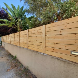 גדר עץ עם תאורה מובנית לצד שביל