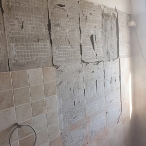 קיר עם אריחים שבורים בתהליך שיפוץ