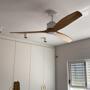 מאוורר תקרה עם כנפיים מעץ מותקן על תקרה לבנה