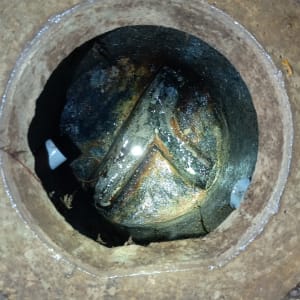 פתח ביוב עם צינור מתכת חלוד