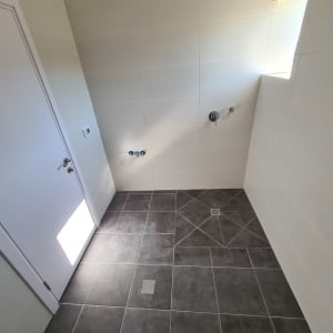 חדר אמבטיה עם אריחים חדשים על הרצפה והקירות