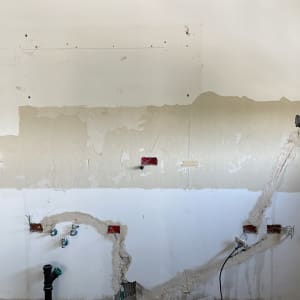 קיר עם חוטי חשמל וצינורות חשופים