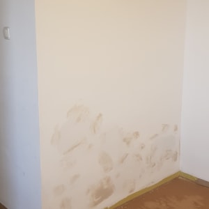 קיר עם תיקוני טיח, נייר דבק על הרצפה