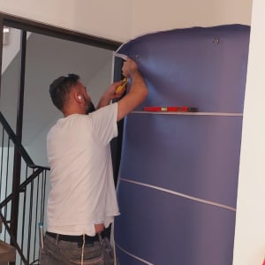 אדם מתקין ציפוי דלת בעזרת כלי עבודה