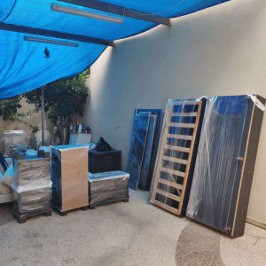 רהיטים עטופים בניילון תחת כיסוי כחול בחצר