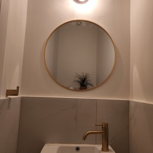 ברז זהב מותקן בכיור לבן בחדר אמבטיה