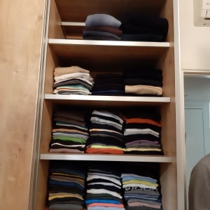 מדפים עם בגדים מקופלים ומסודרים בארון עץ