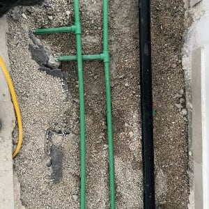 צינורות ירוקים ושחורים מונחים על חצץ