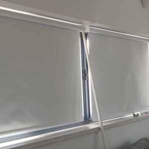 וילונות גלילה לבנים על חלון גדול