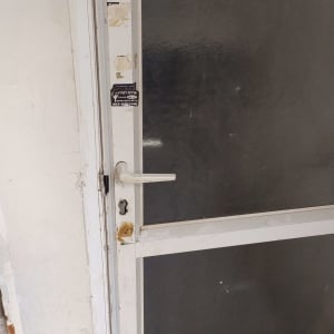 דלת זכוכית עם ידית ומנעול, מדבקה של מנעולן