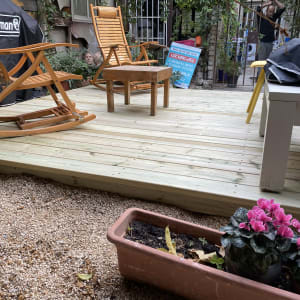 דק עץ עם כיסאות נדנדה ועציצים