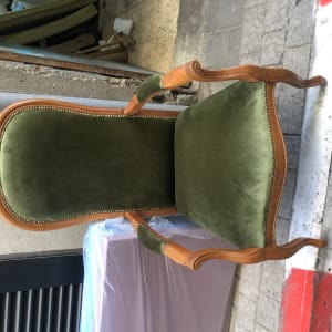 כיסא מרופד בירוק עם מסגרת עץ מעוצבת