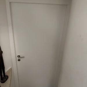 דלת לבנה עם ידית מתכת כסופה