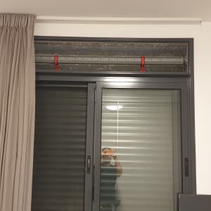 תריסים סגורים בחלון עם מסגרת מתכת אפורה