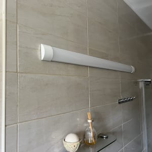 מנורת לד מותקנת על קיר אריחים בחדר אמבטיה