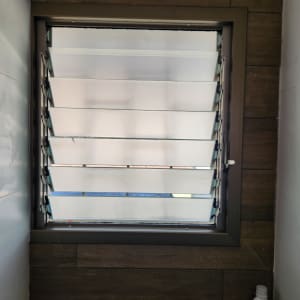 חלון עם תריסי אלומיניום פתוחים חלקית