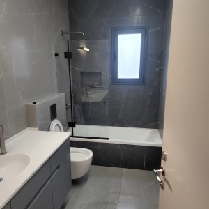 חדר אמבטיה עם כיור, אסלה ואמבטיה נקיים