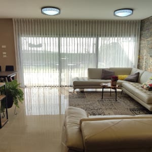 סלון עם וילון לבן שקוף על חלון גדול