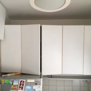 ארונות מטבח לבנים עם דלת פתוחה חלקית