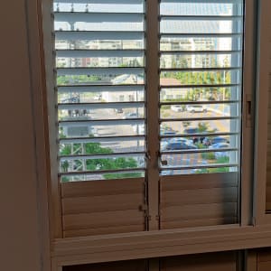 חלון עם תריסי אלומיניום פתוחים למחצה