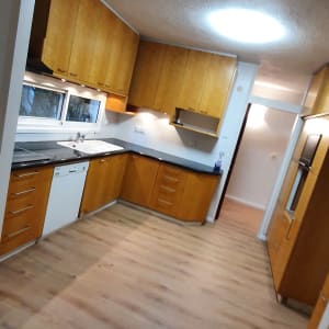 מטבח עם כיור, מדיח כלים ומשטחי עבודה נקיים