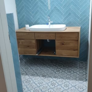 שיפוץ חדר אמבטיה עם אריחים כחולים וכיור חדש