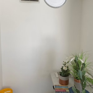 דלי צבע צהוב על הרצפה ליד קיר לבן