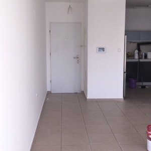 פחית צבע אדום על רצפה ליד קיר לבן