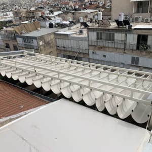 סוכך לבן מתקפל על גג בניין עירוני