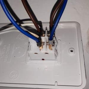 חיבורי חוטי חשמל לשקע לבן בקיר