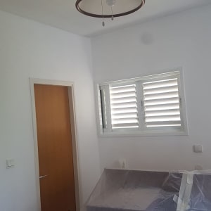 חדר עם דלתות עץ, חלון ותריסים